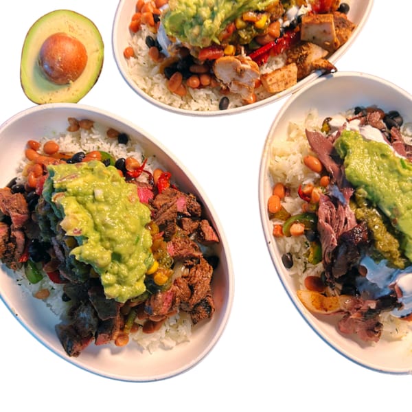 Three Taza Modern Mexican burrito bowls with various meats, rice, beans, and guacamole, with a sliced avocado.