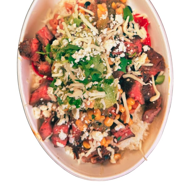 Taza Modern Mexican steak bowl with rice, corn, beans, guacamole, cilantro, and cheese.